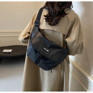 Close-up of the waterproof nylon messenger bag featuring buckle closure and brand label