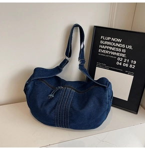 Detail of deep blue washed denim tote bag showing vertical stitching and texture