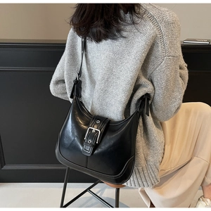 Elegante borsa hobo in pelle nera con fibbia argentata e tracolla regolabile per ogni look
