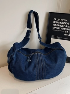 Large dark blue denim shoulder bag with wide strap and zip closure for women