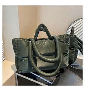 Deep green quilted puffer tote bag with glossy metallic finish for daily commuting