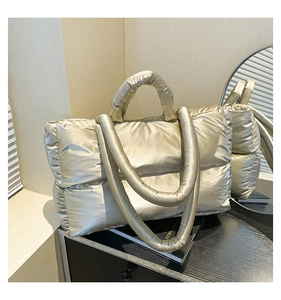 Detailed view of champagne gold quilted puffer tote with metallic glossy finish