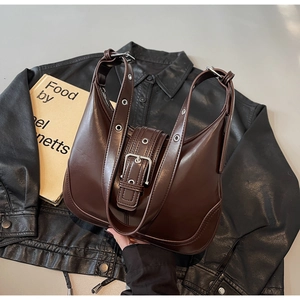 Dettaglio borsa hobo marrone scuro con tracolla con occhielli d'argento su giacca di pelle