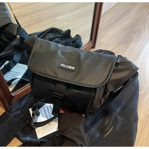 Close-up of black messenger bag made of durable waterproof nylon with secure buckle