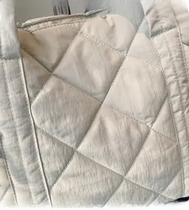 Close-up of lightweight quilted nylon fabric detail on casual puffer tote bag