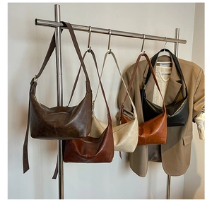Collection of retro crescent leather bags in five colors hanging on a rack display