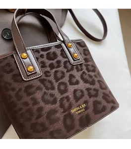 Close-up of leopard print bucket bag with golden rivets and fuzzy texture detail