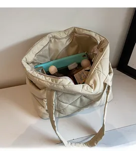 Detailed interior of beige quilted tote bag showing large capacity and side zipper pocket