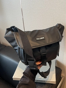 Minimalist black waterproof messenger bag with adjustable strap and buckle closure