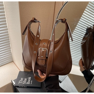 Dettaglio borsa vintage marrone con fibbia argento e dettagli della tracolla con occhielli