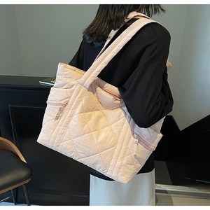 Back view of model wearing a large pink quilted tote bag with diamond stitching