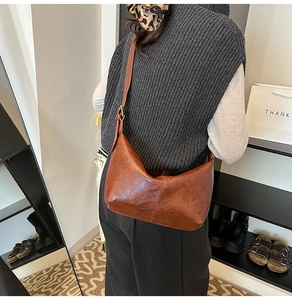 Detail of vintage brown crescent shoulder bag featuring premium oil wax leather and metal buckle