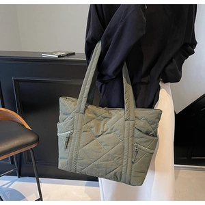 Detail of army green quilted tote bag with side zipper pocket and rhombic stitching