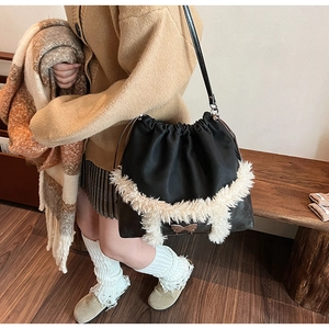 Detail of black drawstring bag with white faux fur trim and metal butterfly buckle