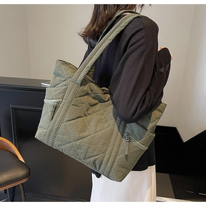 Detail of olive green quilted tote bag showing waterproof fabric and zip pocket side view