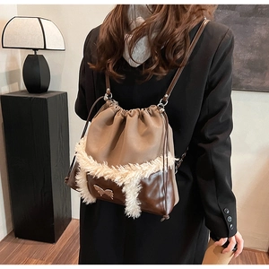 Detail of drawstring backpack with plush trim and gold butterfly logo on a female model