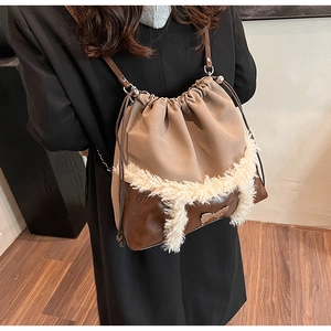Detail view of drawstring bucket bag with fleece trim and metallic bow accent