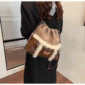 Detail of drawstring bag with brown leather, khaki fabric, and white faux fur trim