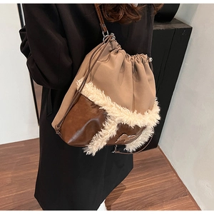 Detail of winter bucket bag with brown leather and beige fabric featuring a fur collar