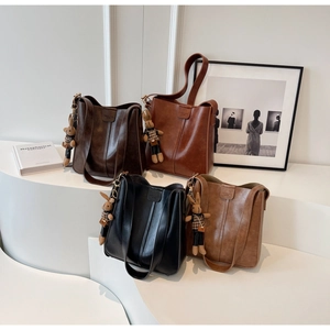Detailed display of four retro bucket bags in black and brown with plush bunny charms