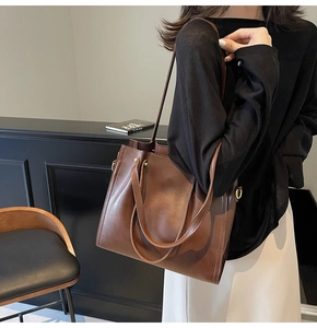 Deep brown large leather tote bag with long handles shown on model in a modern interior