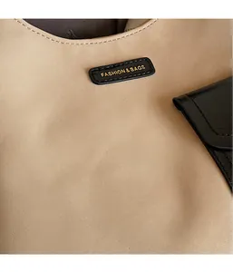 Close-up of textured beige leather with Fashion & Bags gold lettering and black edge stitching