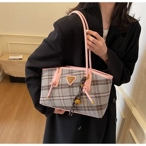 Vue détaillée du sac cabas à carreaux rose et gris avec anses en cuir et logo en métal