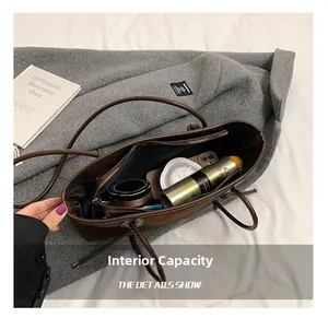 Macro view of spacious interior of dark brown vintage tote bag showing daily essentials