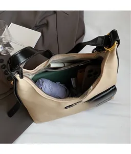Detail view of spacious beige hobo bag interior holding phone, umbrella and notebook