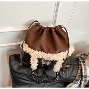 Close-up of stylish bag featuring plush faux fur trim and silver butterfly emblem