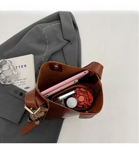Detail of spacious brown bucket bag interior showing tablet and daily essentials storage