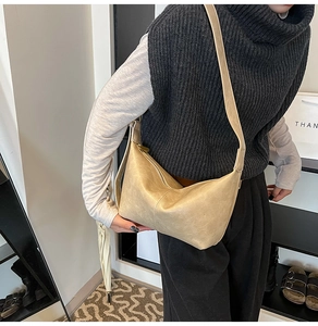 Detail of light beige pleated crossbody bag with a semi-circle shape and adjustable strap