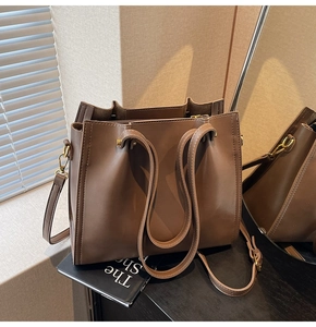 Close-up of chocolate brown tote bag with refined stitching and gold-tone metal hardware