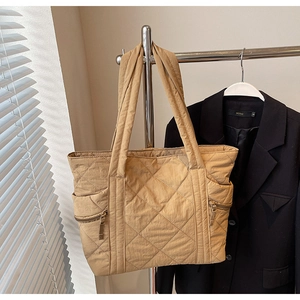 Detail of khaki quilted tote bag with side zipper and large capacity for daily commuting