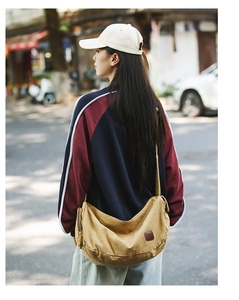 Outdoor-Aufnahme der khakifarbenen Canvas-Umhängetasche mit braunem Leder-Patch