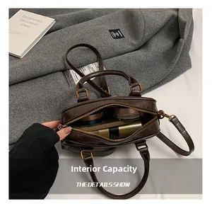Detailed interior of a brown leather Boston bag showing large capacity for daily items