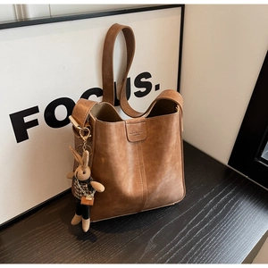 Detail view of vintage brown bucket bag with textured leather and cute bunny charm