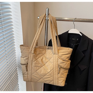 Quilted khaki tote bag featuring side zipper pocket detail and lightweight nylon fabric