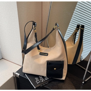 Detail of canvas tote bag with black leather pocket and elegant golden metal studs