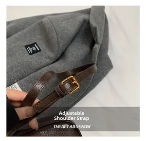 Macro view of adjustable dark brown leather shoulder strap with golden KOSK buckle