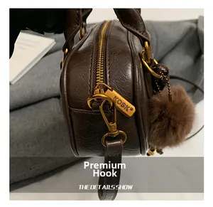 Detail of premium golden metal hook and dark brown oil wax leather texture on bag