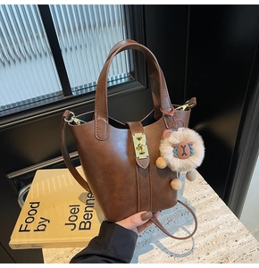 Brown leather bucket bag with gold lock, detachable strap and plush sheep charm