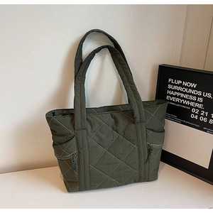 Macro view of army green quilted nylon tote bag with rhombus pattern and side zipper pocket