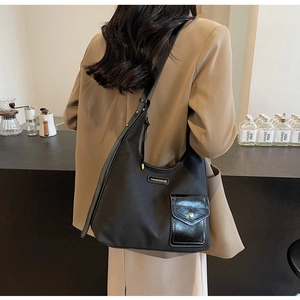 Detail of black nylon tote with leather pocket and gold Fashion & Bags logo plate