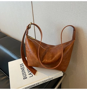 Detail of vintage brown crescent bag with metal zipper and adjustable leather strap