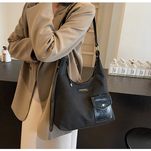Detail shot of black nylon tote bag showing material texture and fashion brand tag