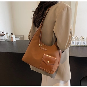 Close-up of caramel brown shoulder bag showing nylon texture and gold buckle detail