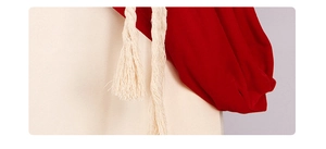 Detail of medieval missionary costume featuring red hood and white cotton drawstring tassels
