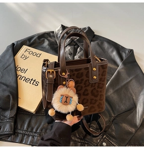 Detail of leopard print bucket bag with suede texture and plush mascot charm