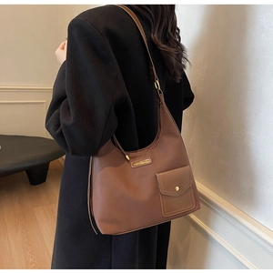Detail of adjustable golden buckle and matte leather texture on brown shoulder bag